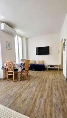a living room with a couch and a table and chairs at Studio Nice Centre - Climatisation in Nice