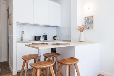 a kitchen with wooden stools at a kitchen counter at 10 AMIRAL 201 - Magnifique apt - 2 chambres - Centre-ville in Nice