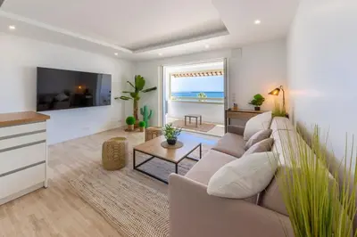a living room with a couch and a tv at 06K1 - Front of the sea-renovated-terraceparking in Saint-Laurent-du-Var