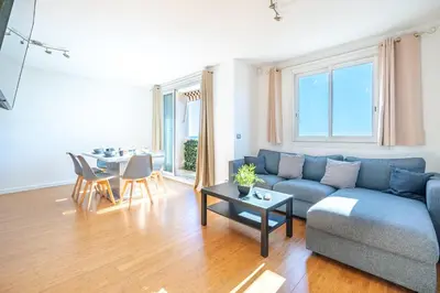 a living room with a blue couch and a table at Superbe 3p vue mer avec parking in Nice