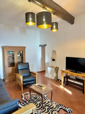 a living room with a couch and a tv at Évasion Authentique à Èze, avec vue Mer in Èze