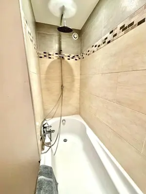 a bathroom with a bath tub with a shower at Évasion Authentique à Èze, avec vue Mer in Èze