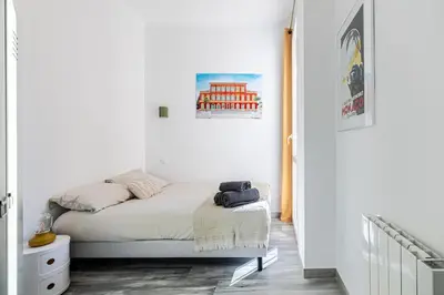 a small bedroom with a bed with white walls at Charming Apt Nice Port Place du Pin with Balcony in Nice