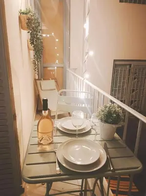 a table with two plates and a bottle of wine on a balcony at Charming Apt Nice Port Place du Pin with Balcony in Nice