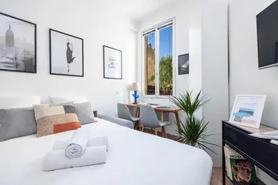 a white bedroom with a bed and a desk at 1 GAUTIER 101 - Joli studio equipe - Quartier du Port in Nice