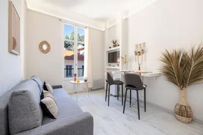 a living room with a couch and a dining room table at 1 GAUTIER 501 - Studio boheme - Quartier du port in Nice