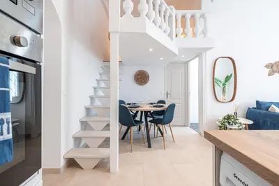 a kitchen and dining room with a spiral staircase and a table at 1 LONGCHAMP - Joli appartement - Carre d Or - Climatise in Nice