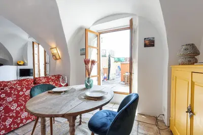 a living room with a wooden table and chairs at 1 SALEYA LOT 2 - Au coeur du Vieux Nice - 1min de la Plage in Nice