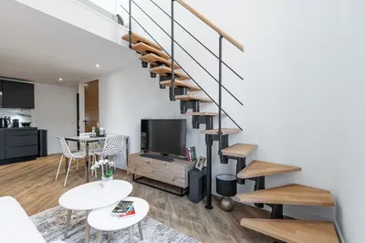a living room with a staircase and a tv at 5 FODERE - Magnifique Duplex - Port de Nice - Dernier etage in Nice