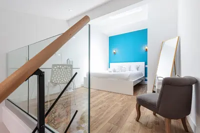 a bedroom with a bed and a chair in a room at 5 FODERE - Magnifique Duplex - Port de Nice - Dernier etage in Nice