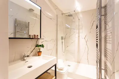 a white bathroom with a shower and a sink at COSY VOLTI AP4434 By Riviera Holiday Homes in Villefranche-sur-Mer