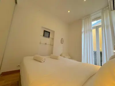 a white bedroom with a bed and a window at ⁂ Appartement cosy avec balcon 300m de la plage in Nice