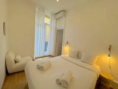 a bedroom with a large white bed with towels on it at ⁂ Appartement cosy avec balcon 300m de la plage in Nice