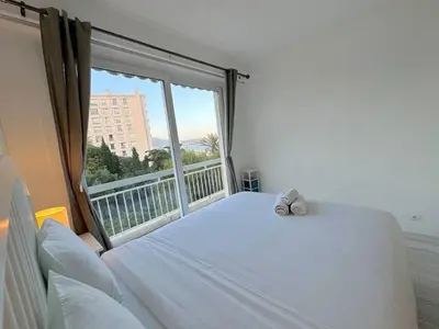 a bedroom with a white bed with a large window at ⁂ Luxueux 3 pièces 300m de la plage clim sauna in Nice