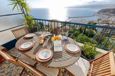 a table on a balcony with a view of the ocean at Magnifique appartement vue mer Mont Borron in Nice