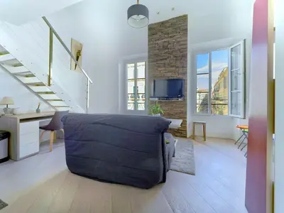 a living room with a couch and a staircase at Cosy duplex, hyper centre, wifi,air conditionner in Nice