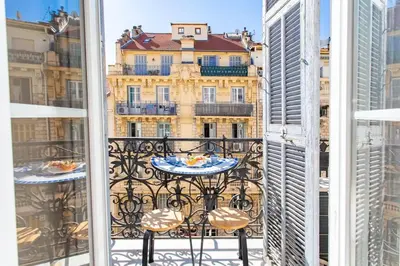 a table on a balcony with a view of a building at #61 1 BDR Rossini Centrale Balcony AC in Nice