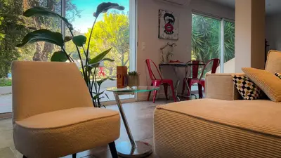 a living room with two chairs and a table and a window at Maison LeFleur in Falicon