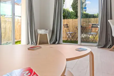 a room with a table and a large window at Le Cosy - Spacious - AC - WIFI - Hippodrome - Racetracks - Hypercentre in Cagnes-sur-Mer