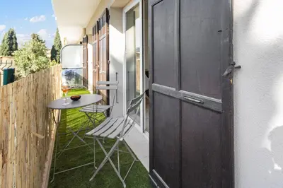 a door leading to an outdoor patio with a table and chair at Le Cosy - Spacious - AC - WIFI - Hippodrome - Racetracks - Hypercentre in Cagnes-sur-Mer