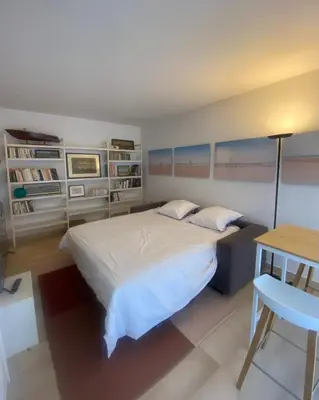a bedroom with a bed and a table and a desk at Lovely studio apartment in Nice