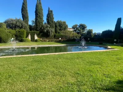 a fountain in the middle of a lawn in a park at Lovely studio apartment in Nice