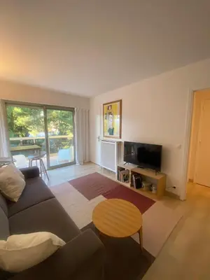 a living room with a couch and a table at Lovely studio apartment in Nice