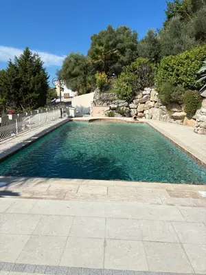 a swimming pool with blue water in a yard at Villa Gloria Nouvel Hôte in Saint-Jeannet