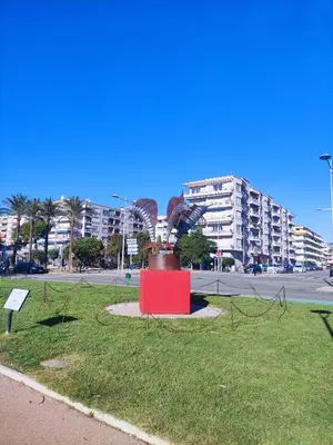 a statue in the middle of a park with buildings at Studio vue mer in Cagnes-sur-Mer
