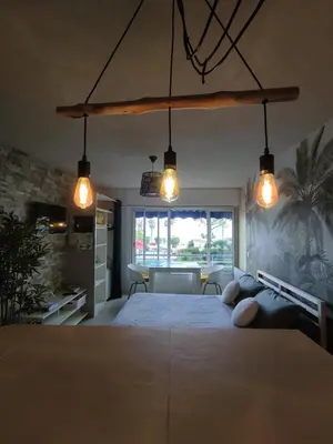 a bedroom with a large bed with three lights at Studio vue mer in Cagnes-sur-Mer
