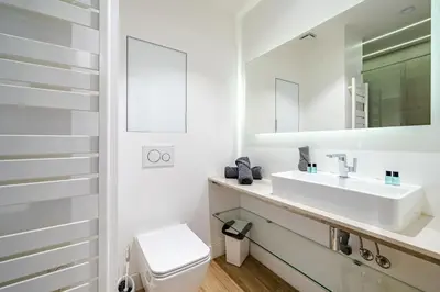 a white bathroom with a sink and a toilet at Cosy 2P Promenade des Anglais in Nice