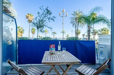 a picnic table with a bottle of wine and two chairs at Cosy 2P Promenade des Anglais in Nice