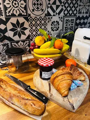 a table with bread and croissants and a bowl of fruit at Amber Apartment Nice - Central Highlights and Beach in Nice