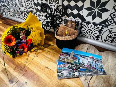 a book and a bouquet of flowers on a table at Amber Apartment Nice - Central Highlights and Beach in Nice