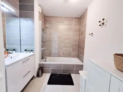 a white bathroom with a tub and a sink at Magnifique Appartement - Parking privé - Nice in Nice