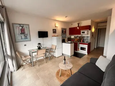 a living room and kitchen with a couch and a table at Heliotel Marine Studio 30m2 très lumineux avec terrasse 17m2 au 3eme étage in Saint-Laurent-du-Var