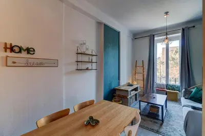 a dining room with a wooden table and a living room at Lovely 2 bedroom Apartment in Nice with Balcony in Nice