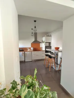 a kitchen with white cabinets and a table at Chambre à 3 min de la Promenade des Anglais à pieds 200m in Nice