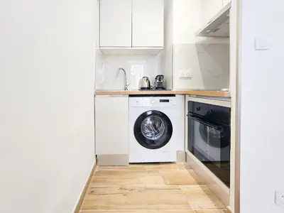 a kitchen with a washing machine and a washer at Lamartine 3 Pers Central WiFi AC in Nice