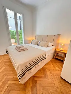 a bedroom with a large bed and a large window at Luxury Central Condo with Private Terrace in Nice in Nice