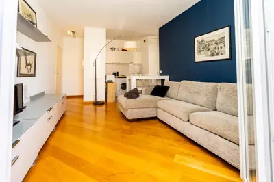 a living room with a couch and a television at Palais Magnan 4 Pers WiFi AC in Nice