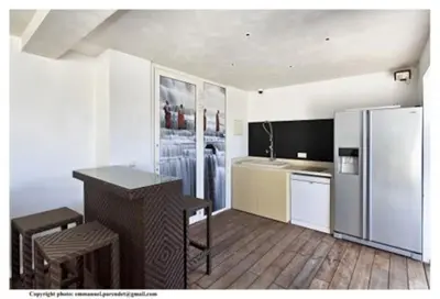 a kitchen with a refrigerator and a table and chairs at MONT BORON - NICE - Splendide villa d'architecte vue panoramique in Nice