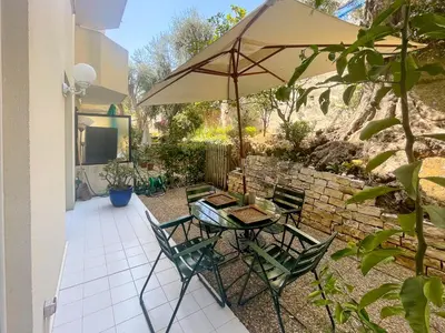 a patio with a table and chairs and an umbrella at La Dolce Vita 6 Pers Parcheggio Terrazza in Nice