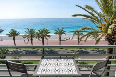 a table and chairs on a balcony overlooking the beach at Promenade 2 Pers Vista Mare WiFi AC in Nice