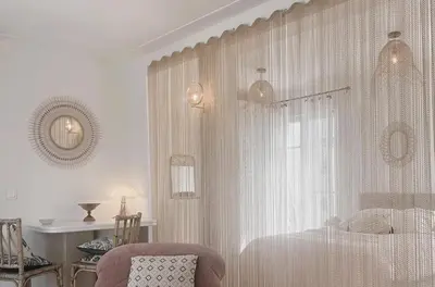 a white bedroom with a bed and a chair at Penthouse avec terrasses panoramiques in Nice