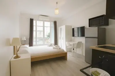 a white room with a bed and a kitchen at Stella Monte 3 AC WiFi 2 Pers in Nice