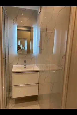 a white bathroom with a sink and a mirror at Studio Lumineux à 2min de là plage in Nice