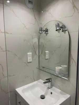 a white bathroom with a sink and a mirror at Studio Lumineux à 2min de là plage in Nice
