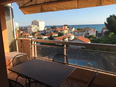a balcony with a table and a view of the city at Le Pêcheur in Cagnes-sur-Mer