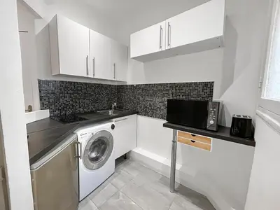 a white kitchen with a washing machine in it at Charmant studio au coeur de Nice in Nice